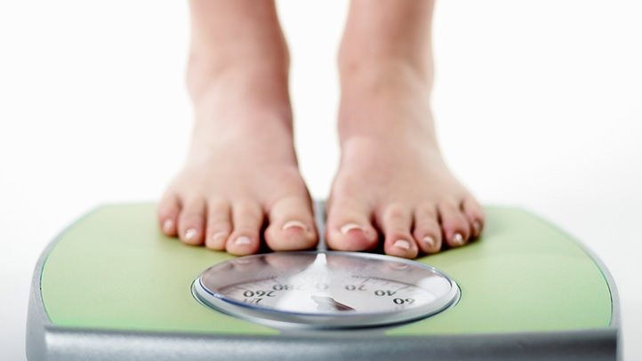 Bathroom scale, measuring tape, healthy food, and modafinil tablets illustrating the discussion of modafinil and weight loss
